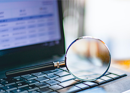 a magnifying glass resting on a laptop keyboard