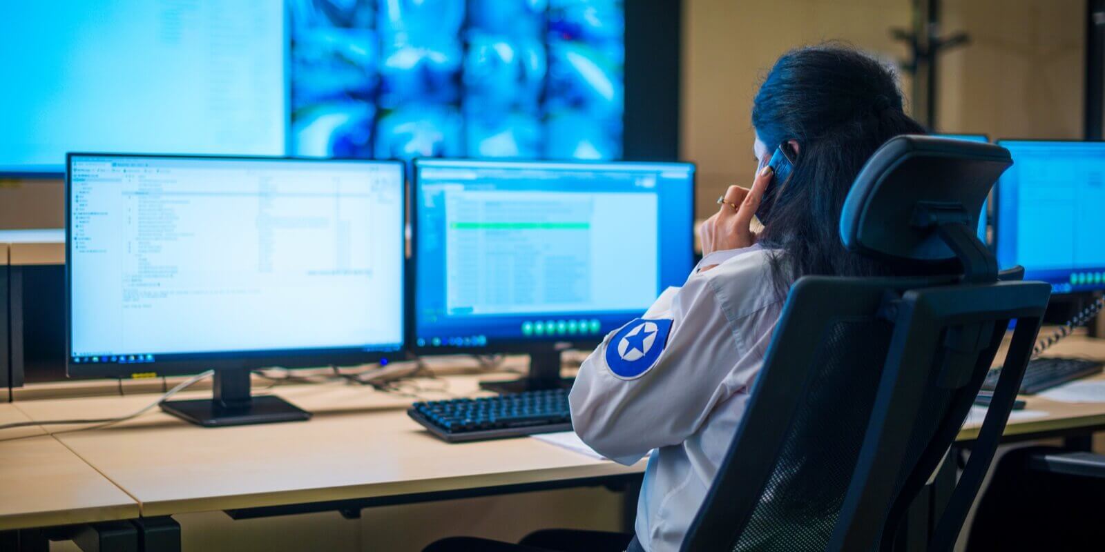 female security guard sitting back and monitoring modern cctv cameras