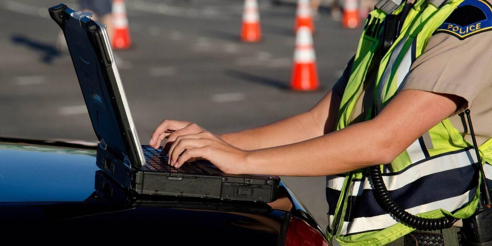 police officer types on her laptop computer while on a call