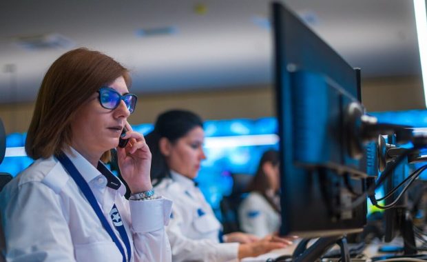 security guard sitting and monitoring modern CCTV cameras in a surveillance room