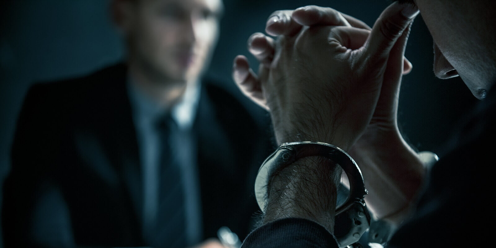 criminal man with handcuffs in interrogation room