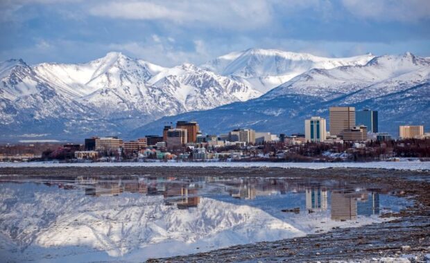 a view of downtown anchorage, AK and snow covered mountains from the bay