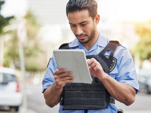 MessengerNow browser-based CJIS workstation interface showing NCIC query results on a ruggedized police laptop.