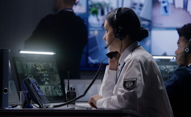 female security officer works on computer in police monitoring center