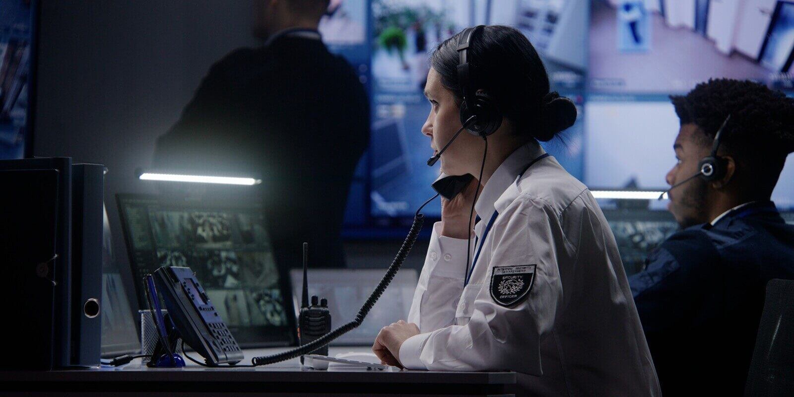 female security officer works on computer in police monitoring center