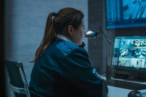 female surveillance operator controls security cameras with face recognition in monitoring center using computer