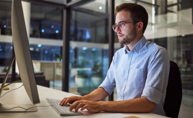 Businessman, computer and night office work for digital programmer, cybersecurity and software design. Thinking web design engineer, developer and worker with technology for ux seo or database coding.