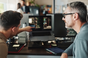 Man, developer and coding support on computer screen in office for testing web application and troubleshooting. Programming, employee or mentor with advice on developing software solution at startup