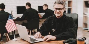 policeman works on laptop in a police station