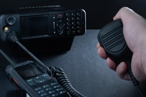closeup of pair of mobile two-way radios for Amateur radio operators against dark background