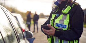female traffic police officer recording details of road traffic accident