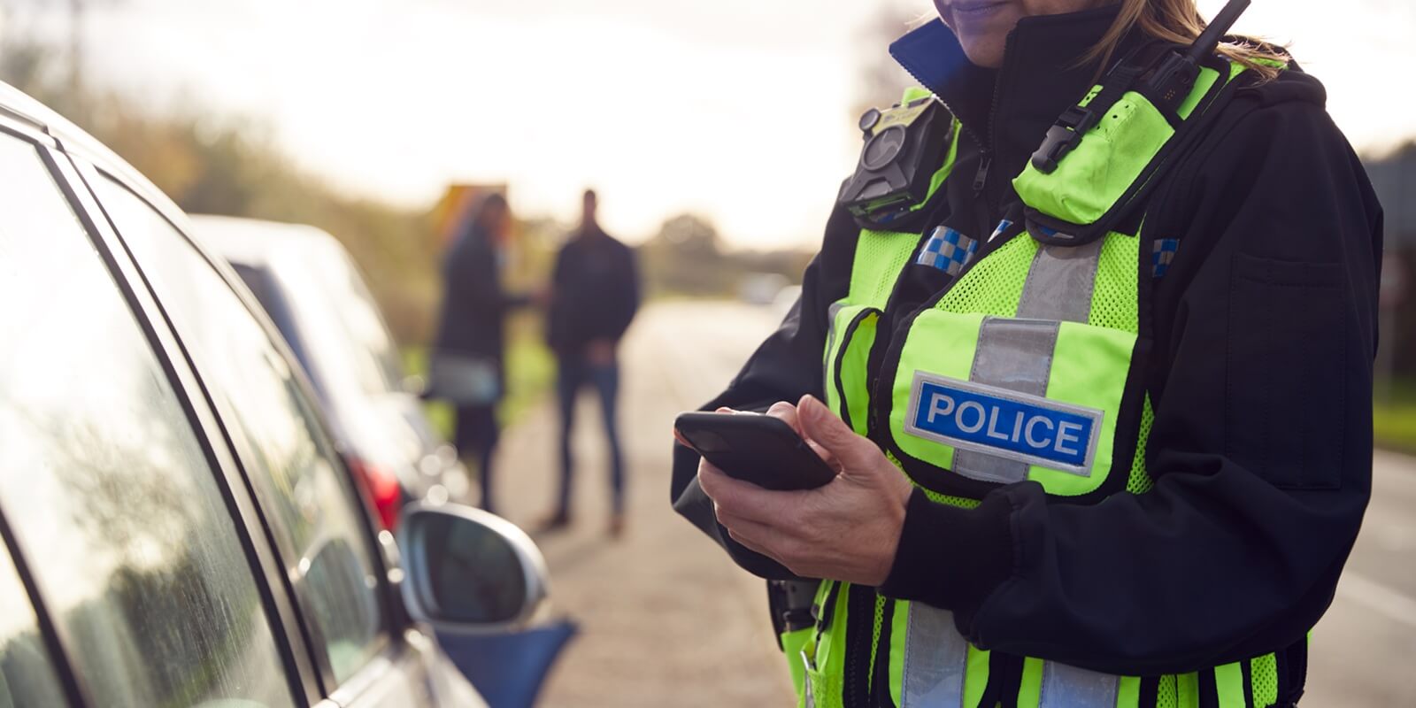 female traffic police officer recording details of road traffic accident